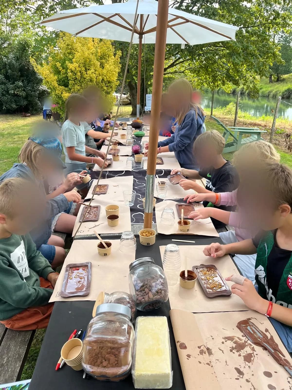 Des enfants fabriquent leur tablette de chocolat lors d'un atelier en plein air, au bord de la Canche