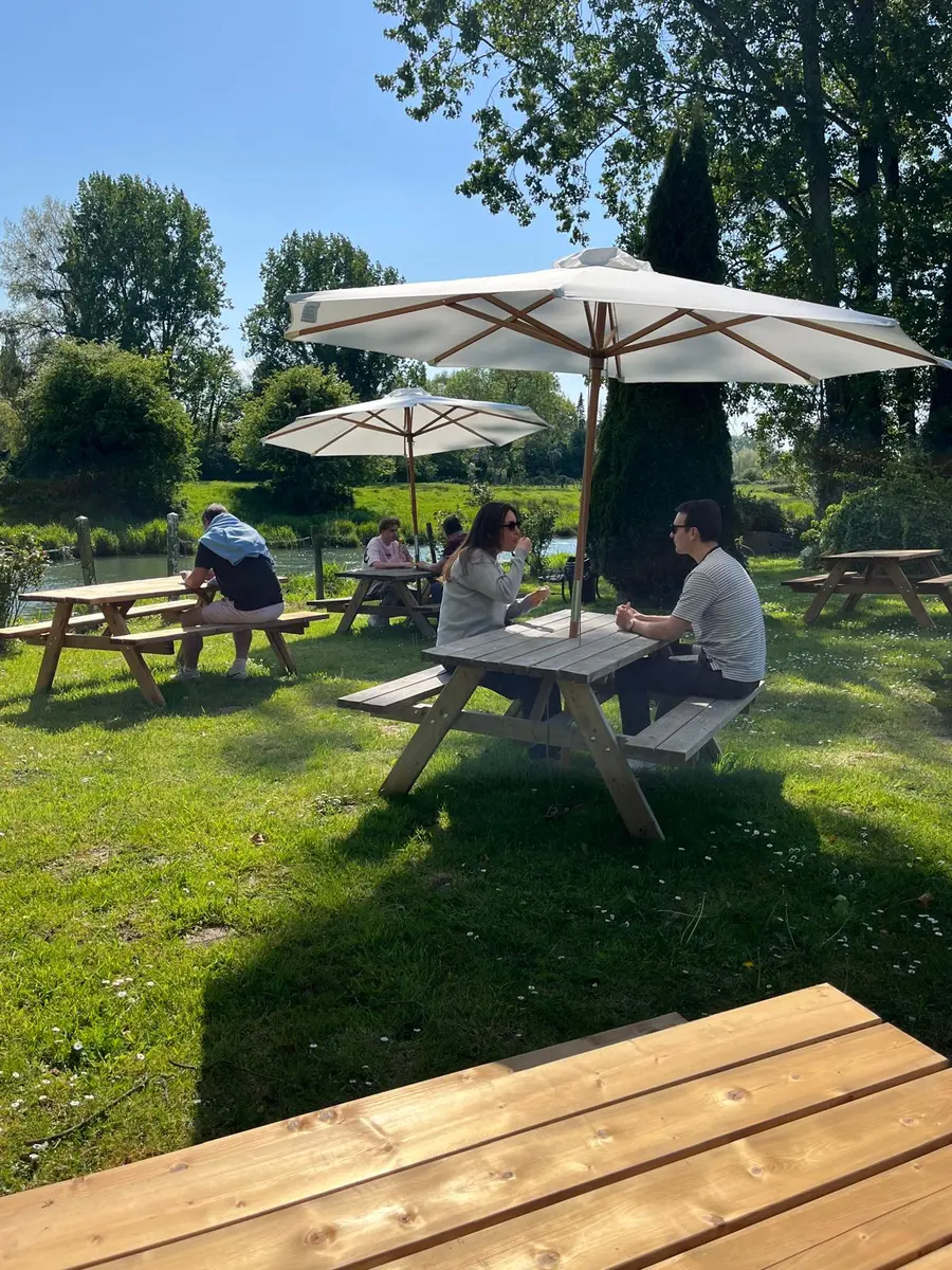 Tables de pique-nique et parasols dans le jardin de la chocolaterie, au bord de la Canche